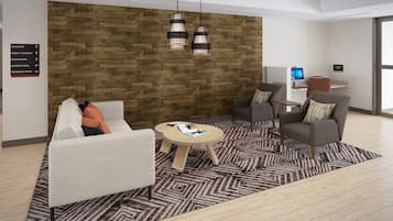 A modern lobby with a wooden wall, two pendant lights, a round table, and two armchairs.