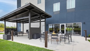 An outdoor patio area with a pergola, seating, and a fire pit. - Candlewood Suites Erlanger South Cincinnati by IHG (Erlanger)