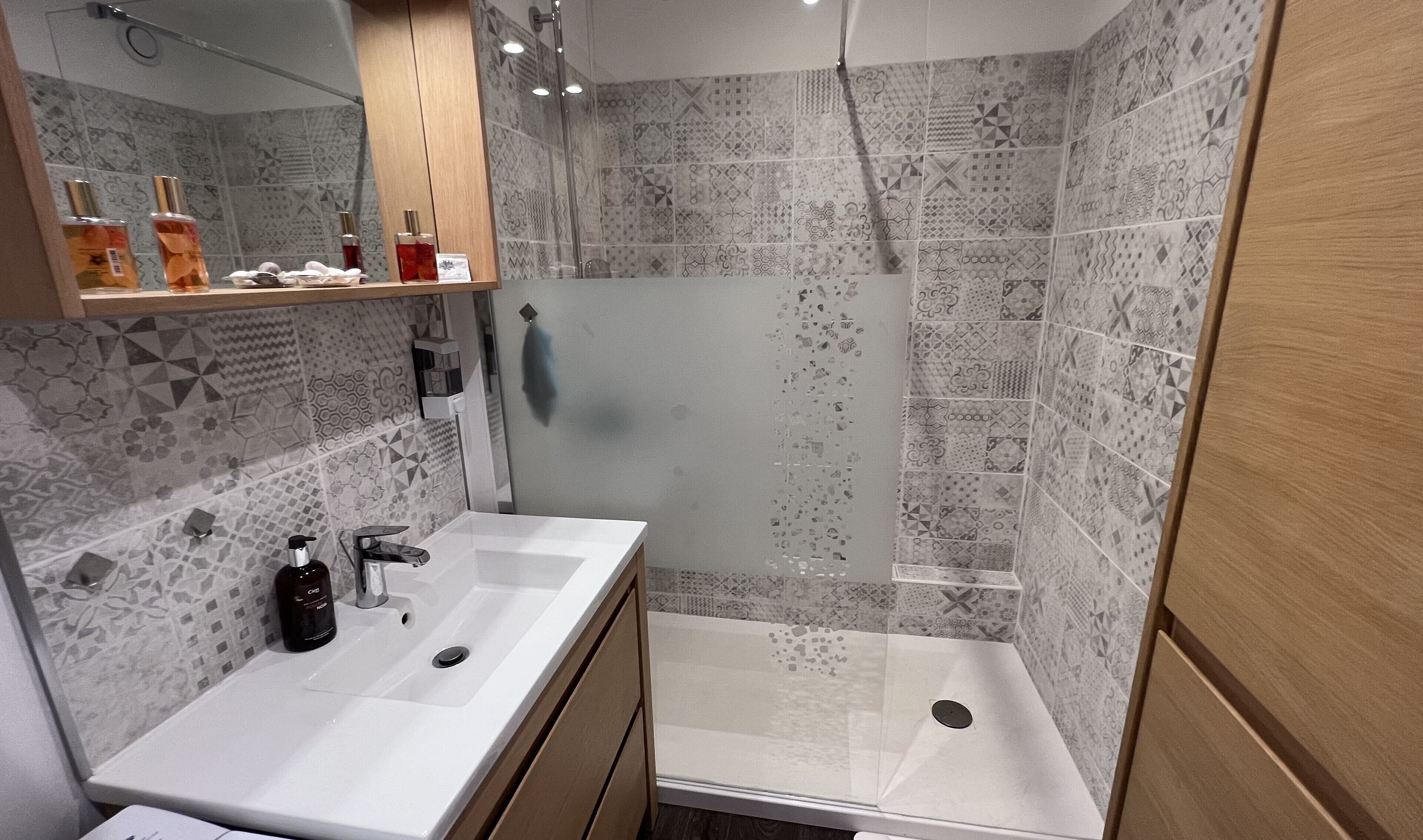 Casa de banho moderna com um espelho grande, duas pias e zona de duche.