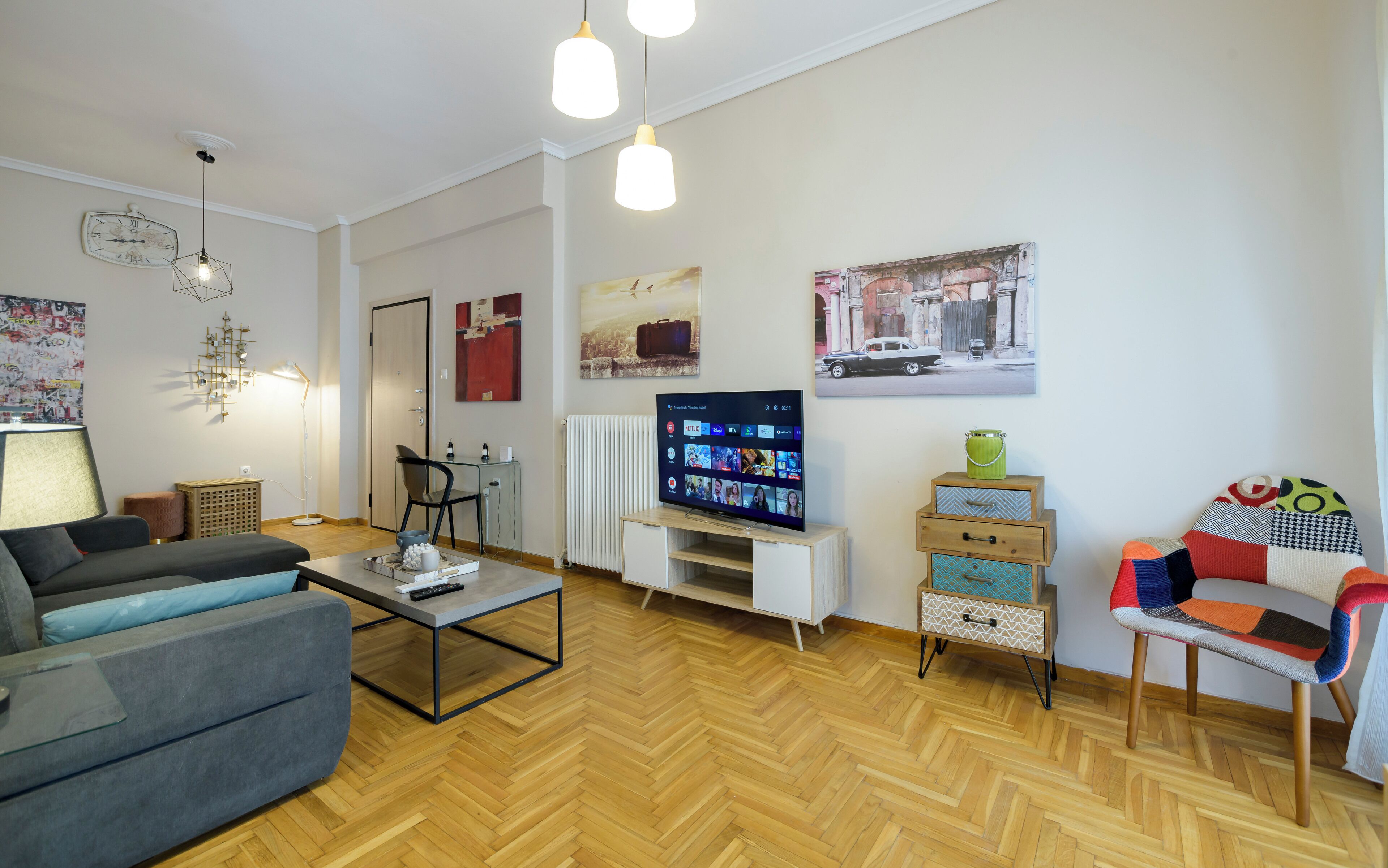 A modern living room with a sofa, coffee table, TV, and decorative items.