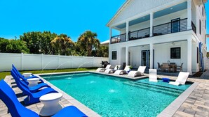 A modern two-story house with a swimming pool, lounge chairs, and a covered patio area. - Vista! Ocean Views from rooftop deck! (Destin)