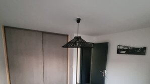 Un dormitorio con cama, armario, puerta y una obra de arte colgada en la pared.