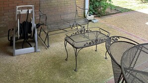 A covered patio area with a hanging plant, a bench, and a table. - Foot ball game weekends and events (Oxford)