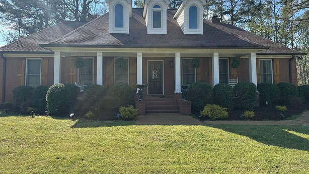 A two-story house with a front porch, a chimney, and a well-maintained lawn. - Foot ball game weekends and events (Oxford)
