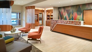 A lobby with a reception desk, seating area, and a wall with geometric patterns. - SpringHill Suites by Marriott Arlington TN (Arlington)