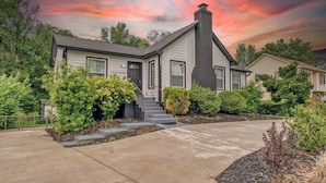 A two-story house with a front entrance, a chimney, and a well-maintained garden. - Stylish Home Near Uptown, UNC, and More! (Charlotte)