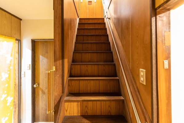 A wooden staircase with a handrail, leading to an elevator. - Karakara (Osaka)