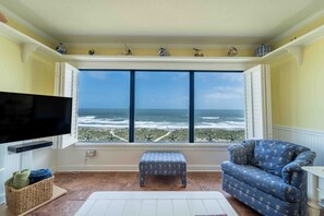 Relax in this ocean-view living room with a comfortable sofa, wooden bench, and flat-screen TV.