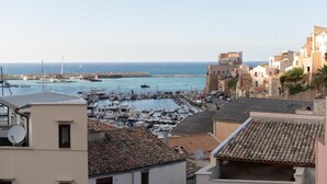A coastal town with a marina, terracotta-roofed buildings, and a clear view of the sea. - Gassa d’Amante (Castellammare del Golfo)