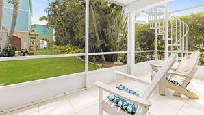 A covered outdoor area with white chairs and a spiral staircase. - Captiva Home New to Rental Market ! (Captiva)