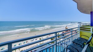 A balcony with a view of a beach and ocean.