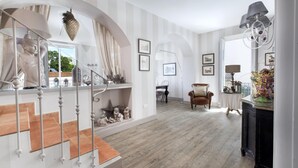 A spacious living area with a staircase, wooden flooring, and a view of the outdoors. - Appartamento Terrazza Tasso (Sorrento)