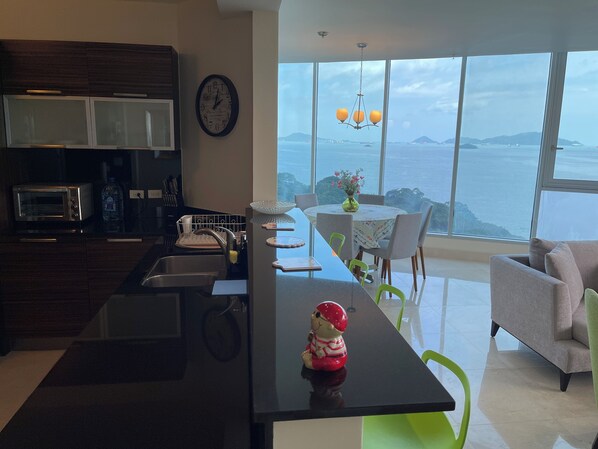 Una cocina moderna con una isla grande, un comedor con vistas y una zona de estar acogedora.
