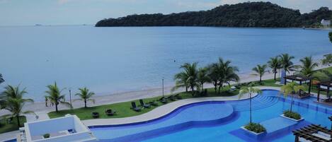 A swimming pool with a view of the beach and a distant island.