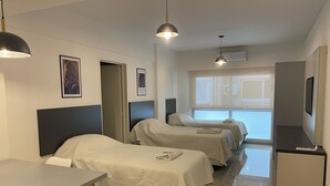Ett hotellrum med två sängar, ett skrivbord och en TV.