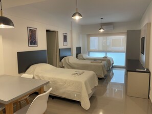 Une chambre d’hôtel avec deux lits, un bureau et une télévision.