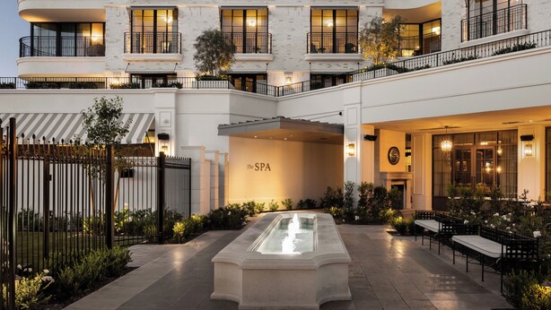 Un hotel con spa, zona de estar al aire libre y una entrada bien iluminada.