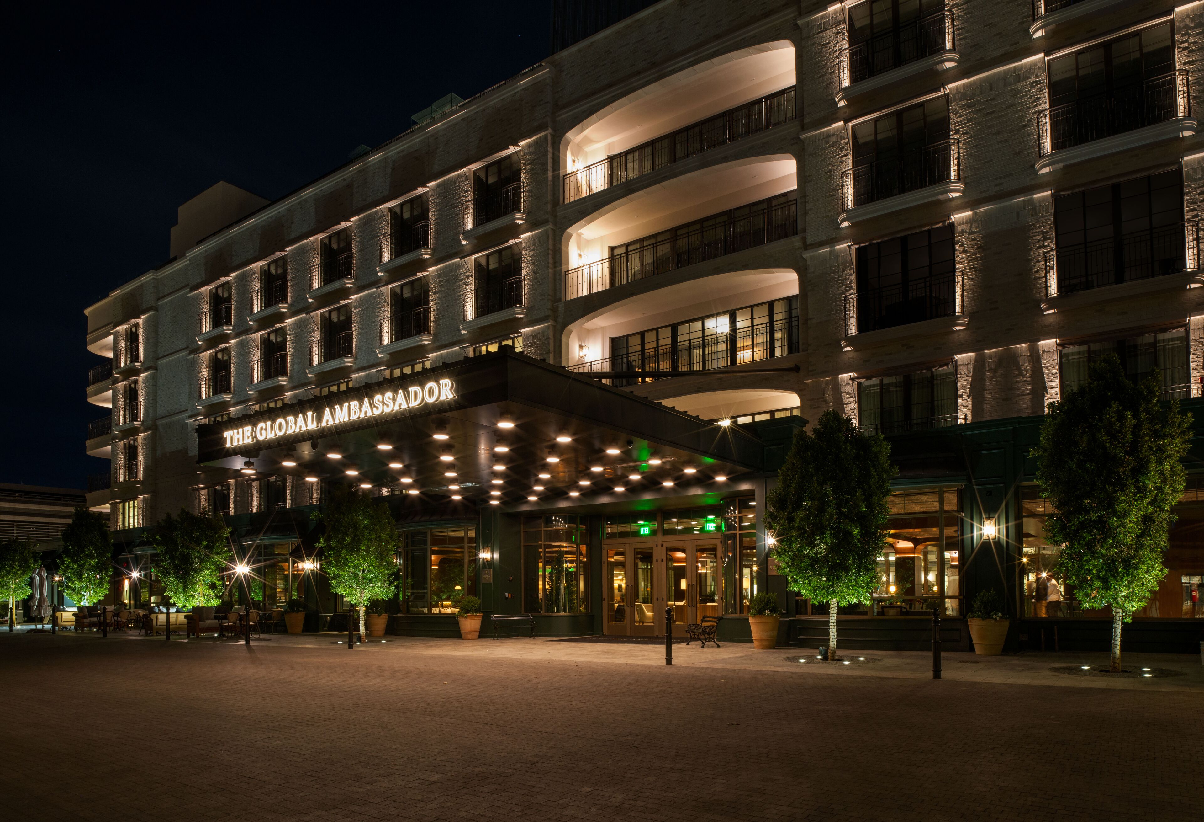 A multi-story hotel with a prominent entrance and a sign reading "The Global Ambassador."