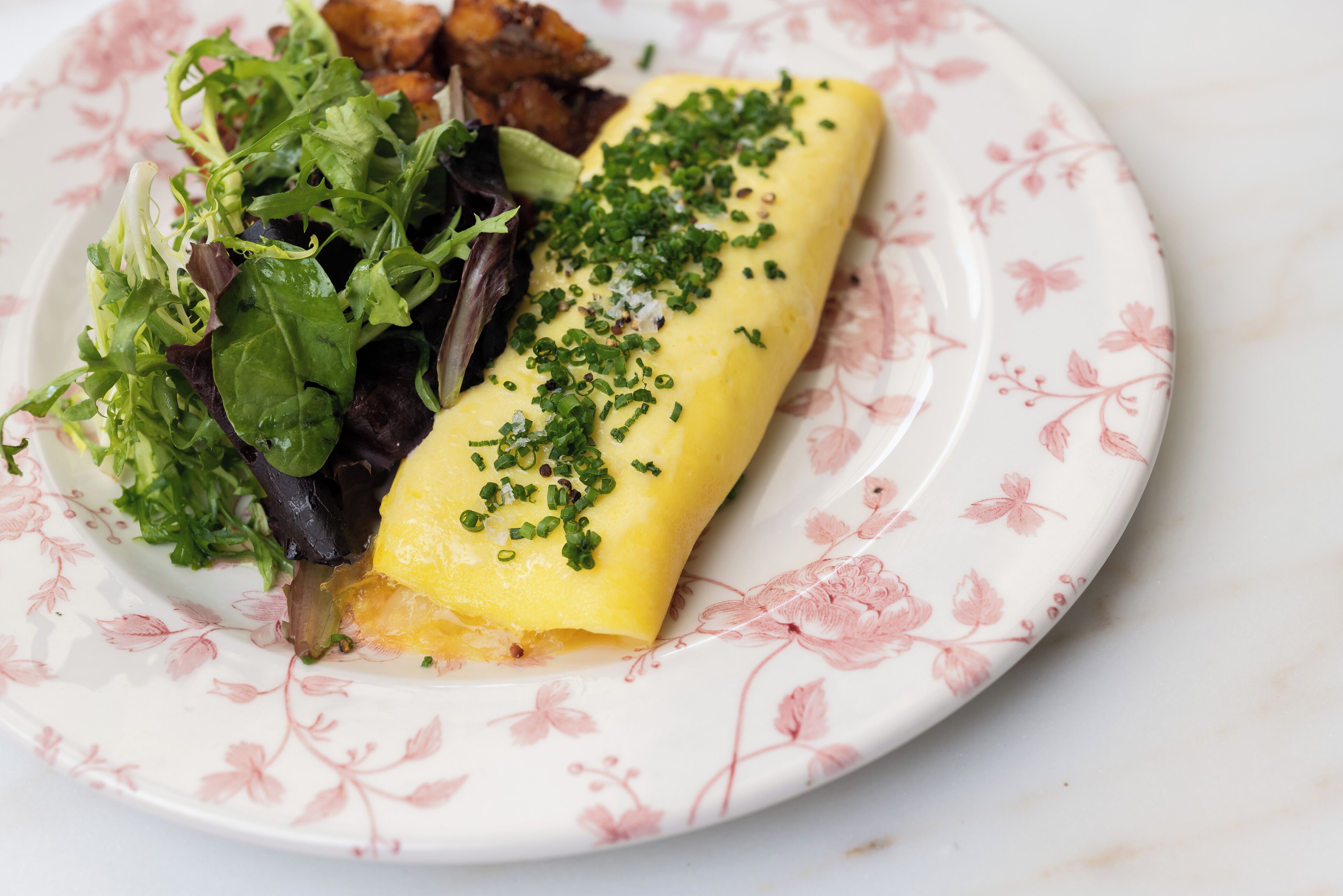 Un plato con tortilla, verduras y un acompañamiento.