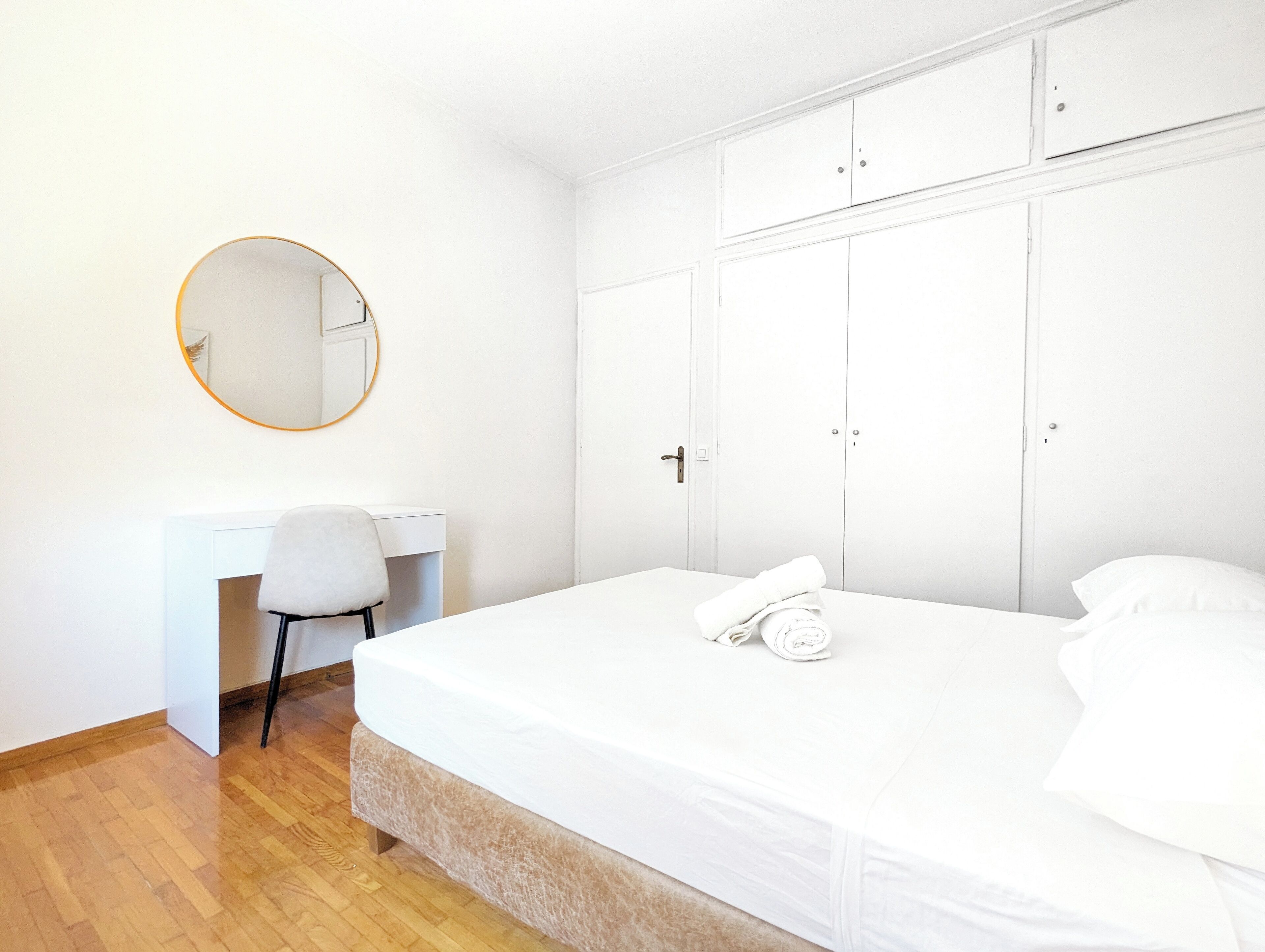 Un dormitorio con cama, escritorio, silla y armario.