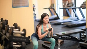 Ein Fitnessstudio mit Trainingsgeräten, Laufbändern und einer Wasserflasche auf dem Boden.