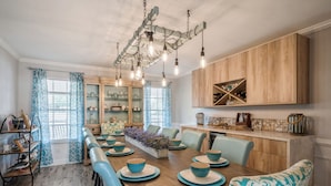 A dining area with a wooden table, blue chairs, and a chandelier. - Beautiful Water Front home in Port St Lucie FL (Port St. Lucie)