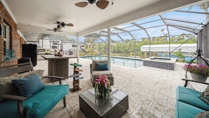 A covered outdoor patio with a pool, seating area, and a view of the pool. - Beautiful Water Front home in Port St Lucie FL (Port St. Lucie)