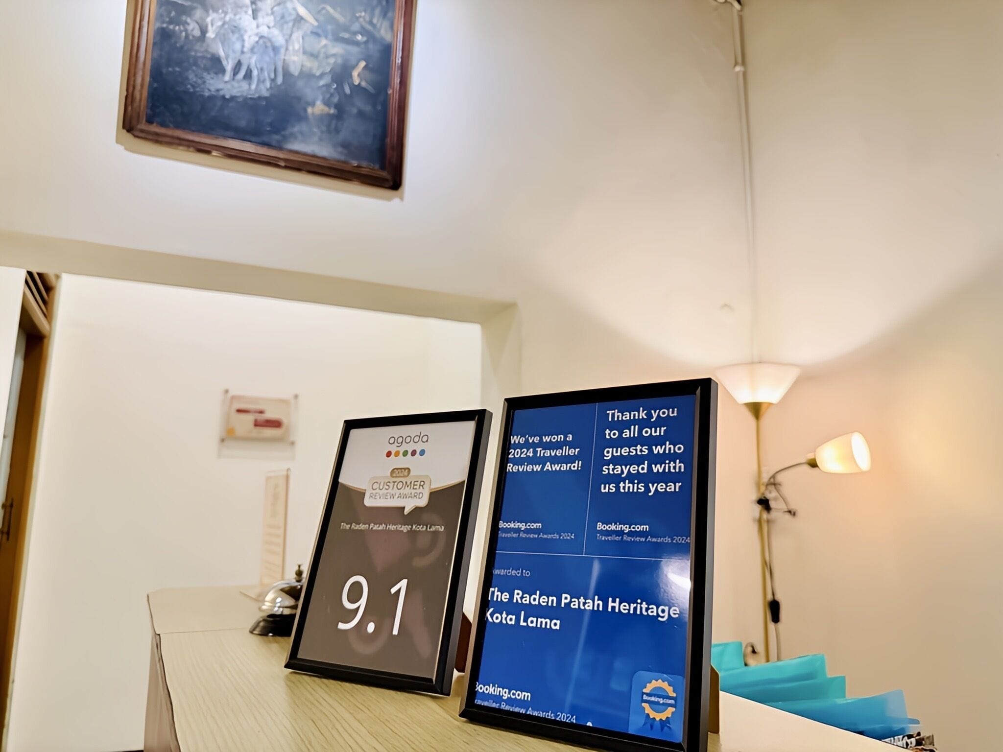 Un comptoir d’accueil d’hôtel agrémenté de trophées et doté d’un écran numérique.