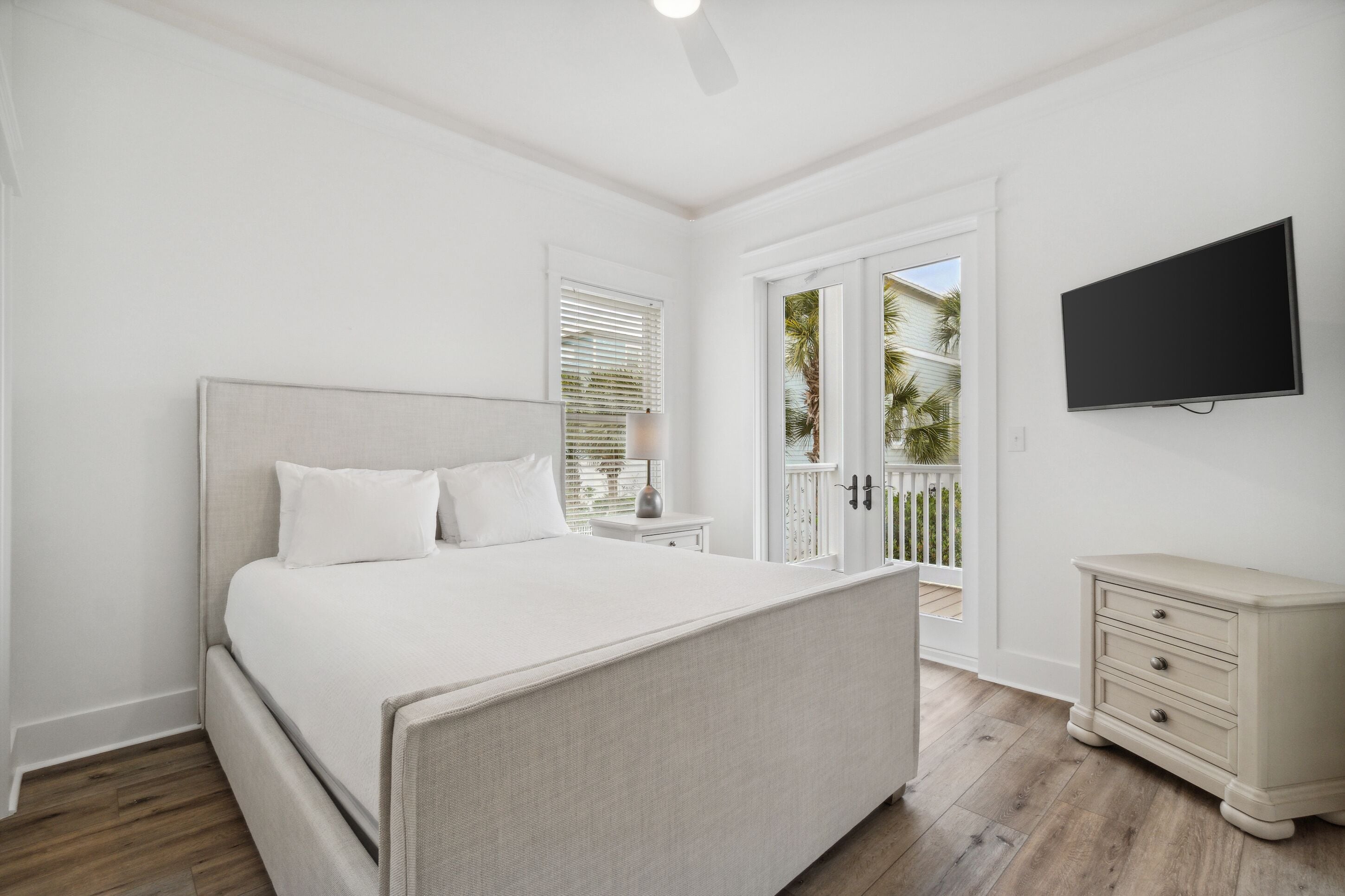 A bedroom with a bed, a nightstand, a dresser, and a TV.