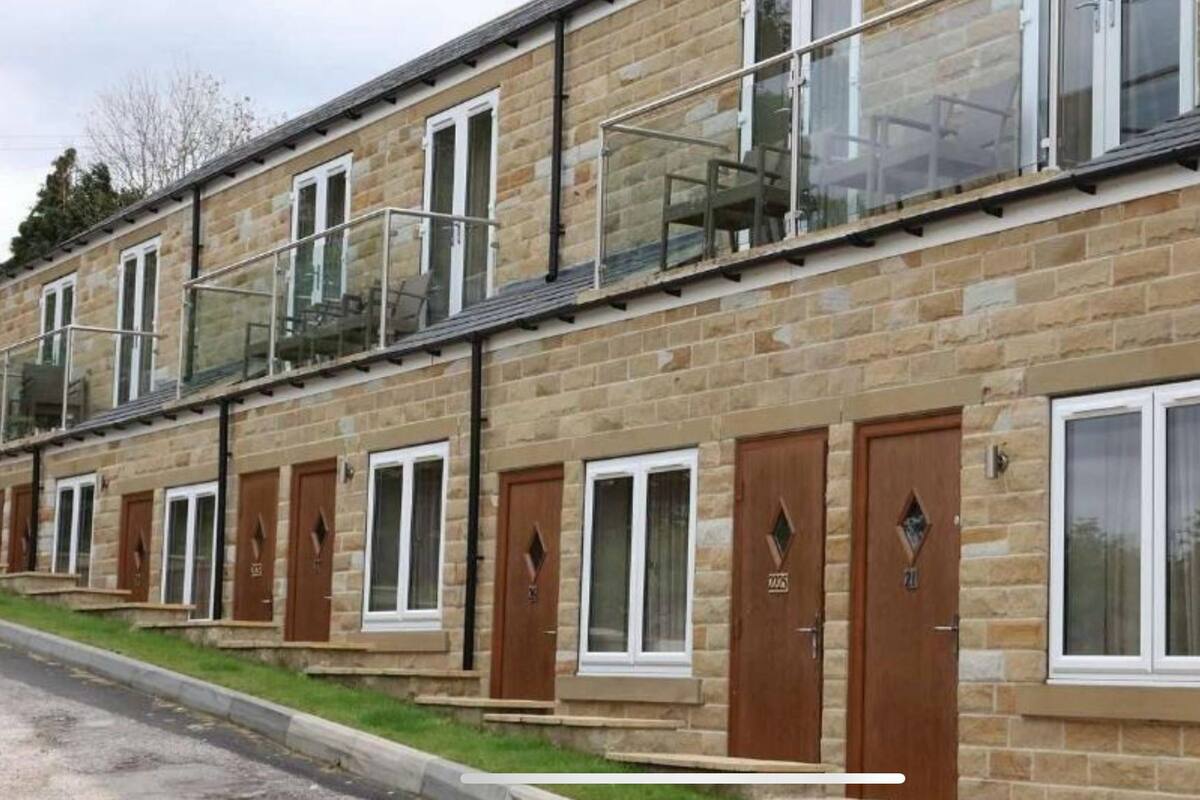 A row of stone buildings with multiple windows and doors, some with glass railings.