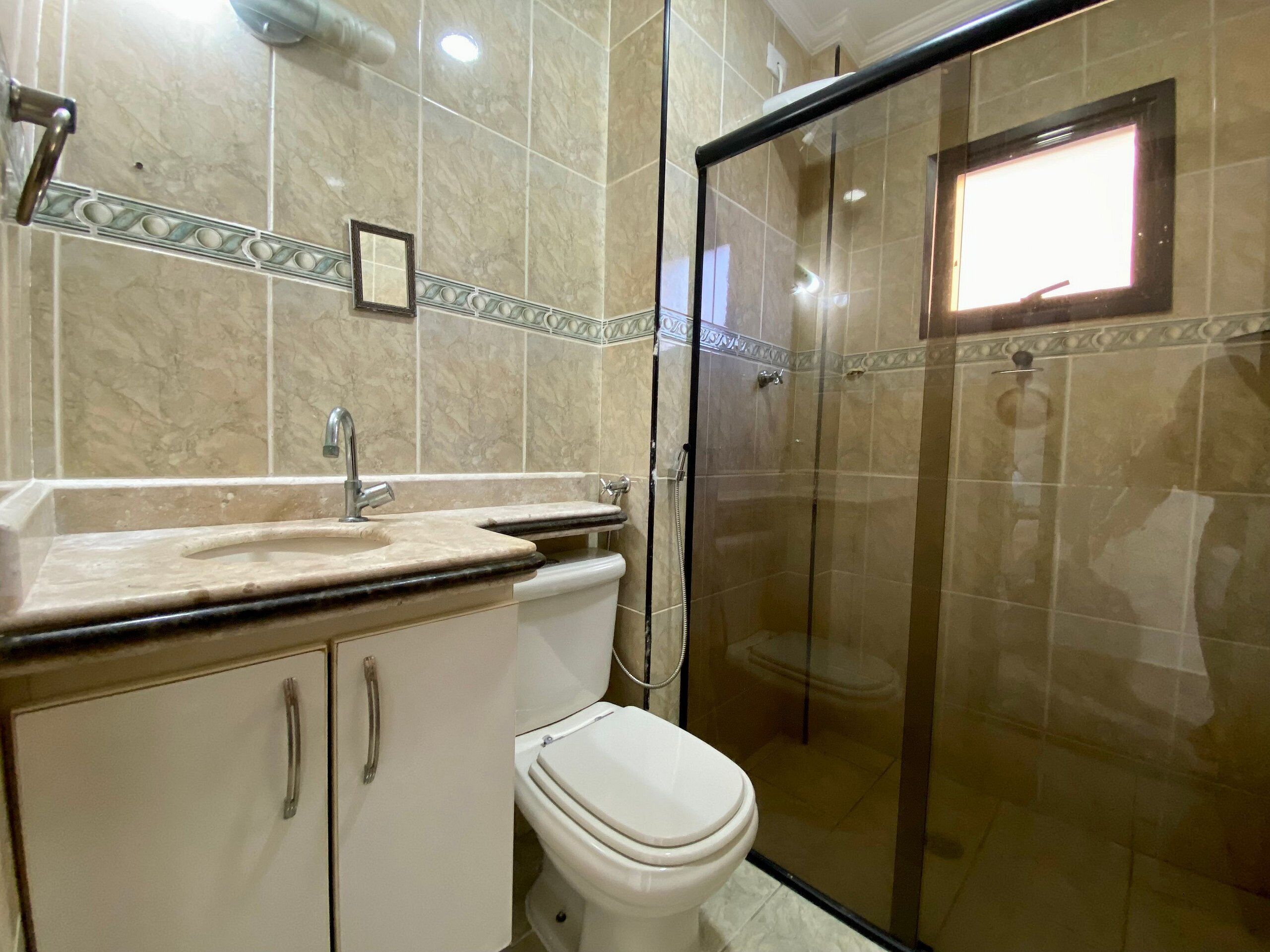 A bathroom with a toilet, sink, and shower.