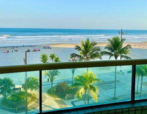 A beach view from a balcony with palm trees, a sandy beach, and the ocean. - Costa do Marfim  (Praia Grande)