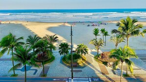 Una spiaggia con palme, cielo sereno e vista sull'oceano.