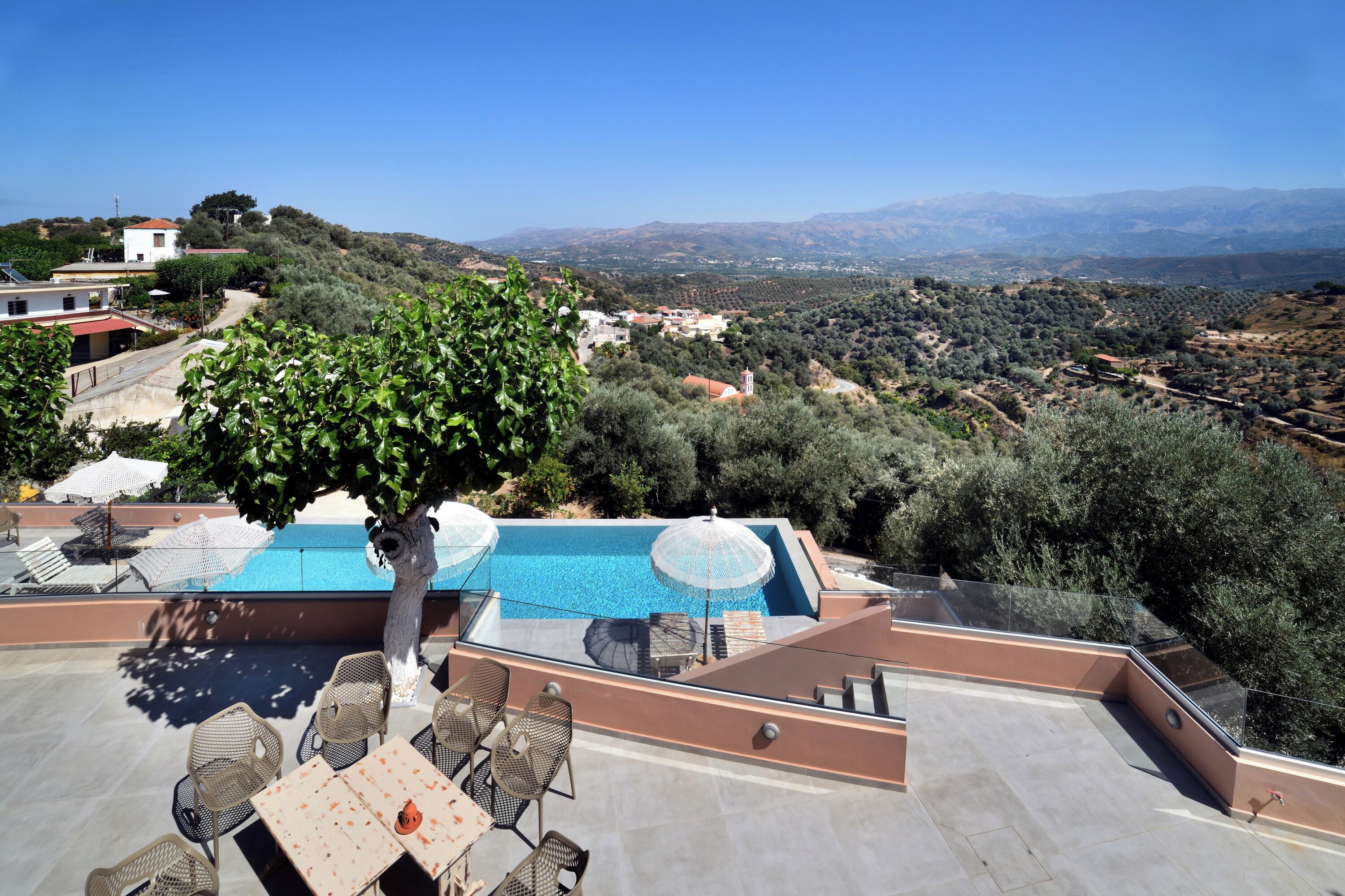 A rooftop pool area with outdoor seating and a view of the surrounding landscape.