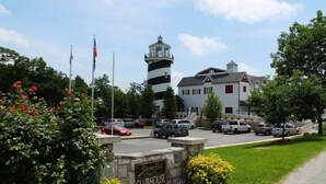 A clubhouse with a lighthouse, a parking lot, and a sign indicating the name. - Branson | Cozy Waterfront Retreat | Pool + Lake (Branson)