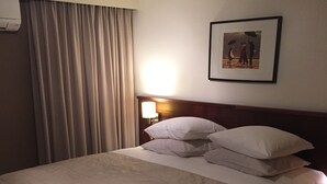 A hotel room with a large bed, a nightstand with a lamp, and a framed picture on the wall. - Hotel Prelude (Aalter)