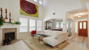 A spacious living room with a fireplace, a large painting, and a high ceiling. - Rosey Bouldin Home + Minutes to DT - Adelaide! (Austin)