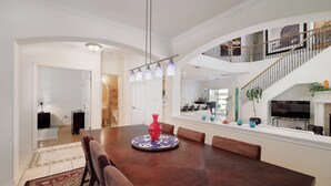 A spacious dining area with a long wooden table, comfortable seating, and a decorative centerpiece. - Rosey Bouldin Home + Minutes to DT - Adelaide! (Austin)