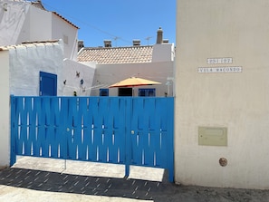 A white building with a blue gate and a sign reading "VILA MACONDO". - Casita en Aldea de Pescadores, en Medio del Pinar y la Playa. Olvídate del Coche (Monte Gordo)