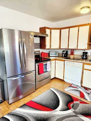 A compact kitchen with stainless steel appliances, wooden cabinets, and a microwave. - Stay right in the heart of Long Beach, WA — steps from the ocean! (Long Beach)