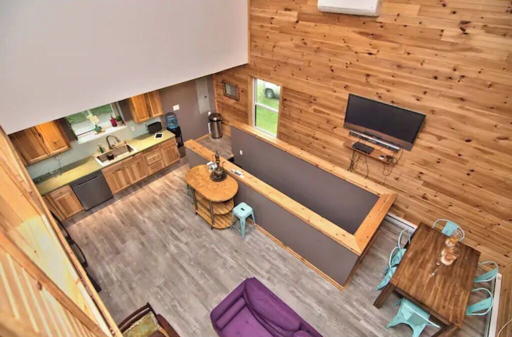 A compact living space with a kitchen, dining area, and a large window.