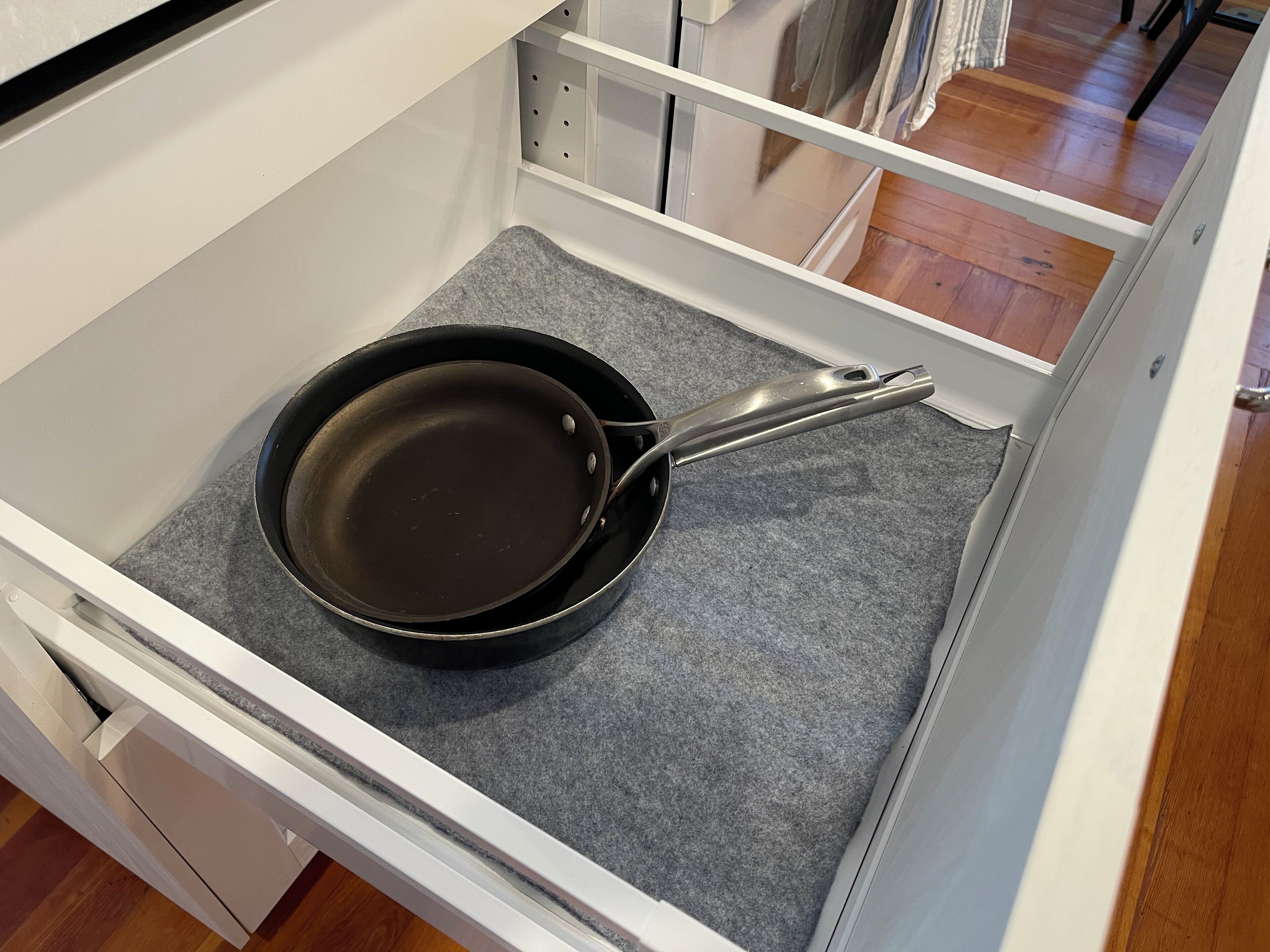 Een keukula met een zwarte koekenpan op een grijze vilten onderzetter.