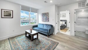 A modern living room with a blue sofa, a coffee table, and a patterned rug.