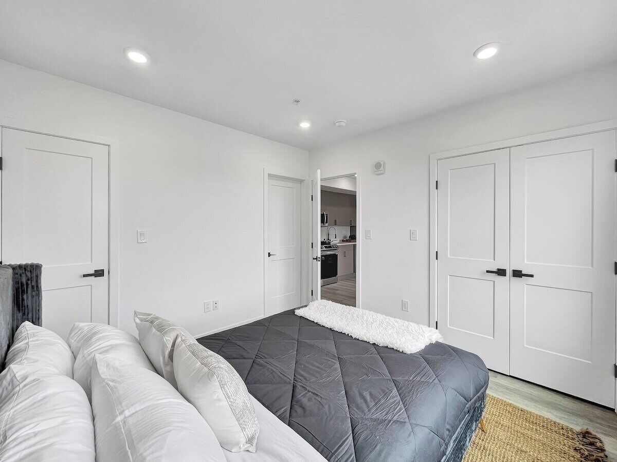 A bedroom with a bed, a sofa, and a wardrobe.