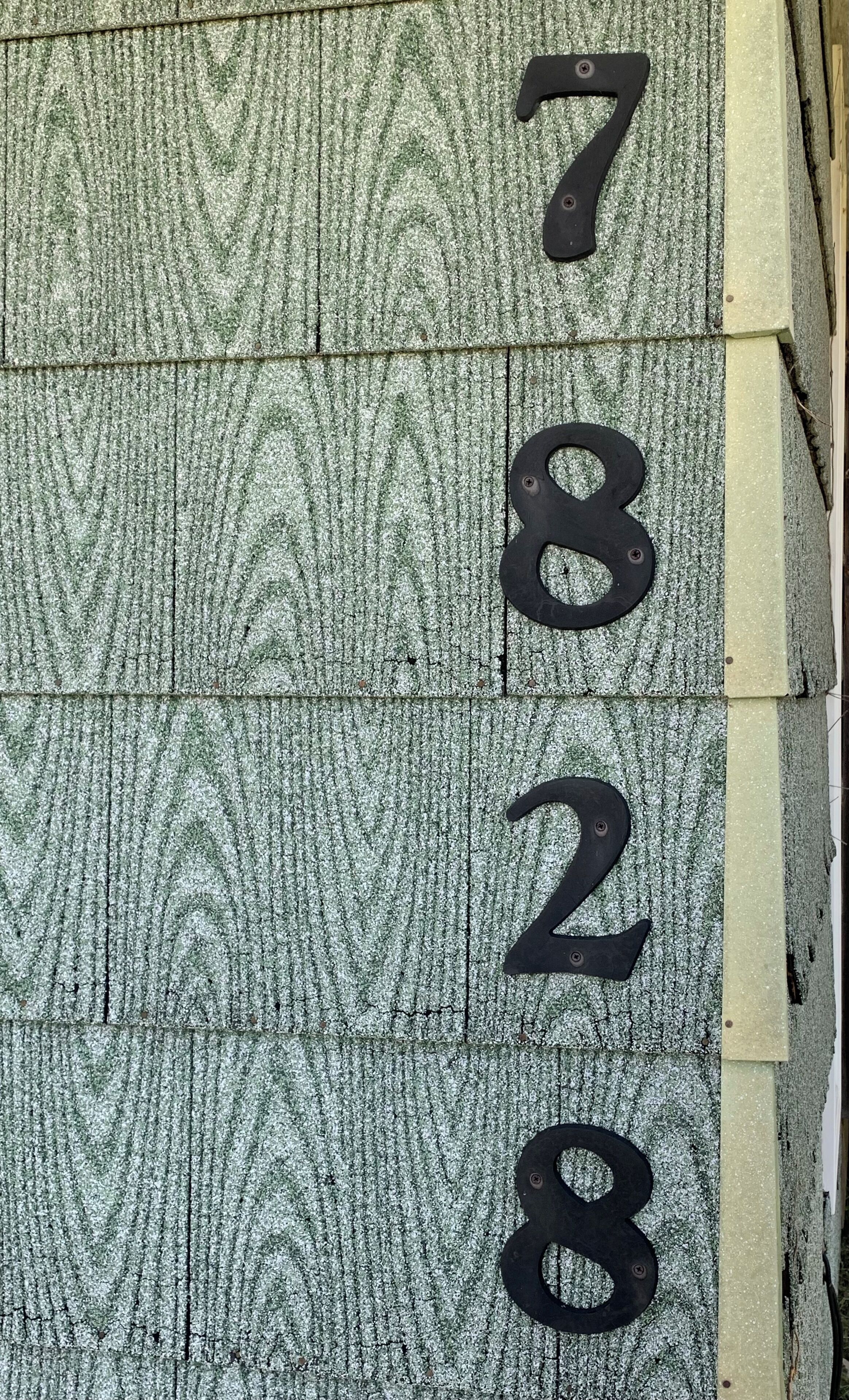 A close-up of a textured wall with numbers 7, 8, 2, and 8 embossed on it.
