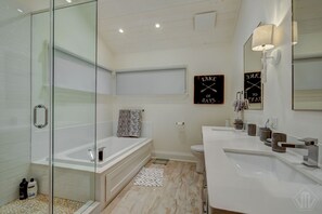 A modern bathroom with a glass shower enclosure, a freestanding bathtub, a toilet, and a vanity with a mirror. - Welcome to this 4,200 sq. ft, 7 bedroom Cottage on Lake of Bays! Sleeps 16 (Baysville)
