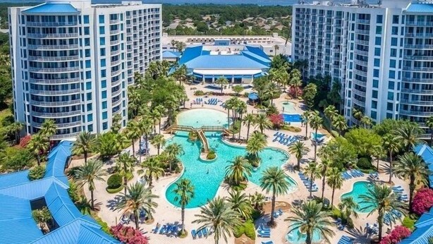 A resort with multiple swimming pools, palm trees, and high-rise buildings. - Rare end unit at the Palms of Destin w/ 2 King beds Steps from the Pool
 (Destin)