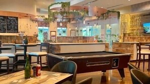 A billiards table in a restaurant with a pool table, seating, and a bar area. - Rare end unit at the Palms of Destin w/ 2 King beds Steps from the Pool
 (Destin)