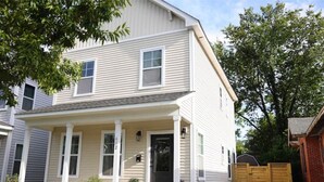 A two-story house with a front porch, a garage, and a gated backyard. - Cozy 2-Story House in Historic Downtown Wilmington. Walk to weddings & concerts! (Wilmington)