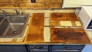 Eine Küche mit Holztischplatte, Spüle und Mikrowelle.